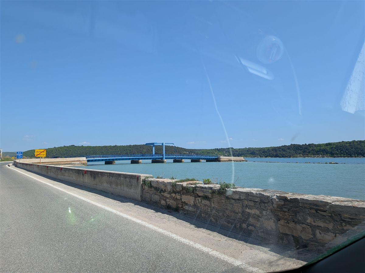 First view of the Adriatic coast — turquoise water and a blue drawbridge near Poreč